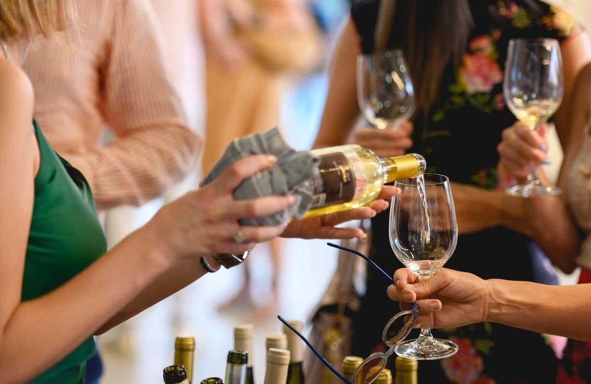 Crowd of people drinking and pouring wine